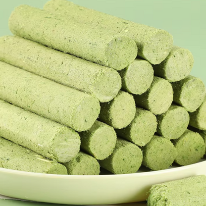 Stack of green Cat Grass Sticks on a white plate with a green background