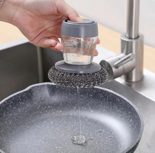 Person using a kitchen Soap Dispenser Steel Brush to clean a pot under running water.